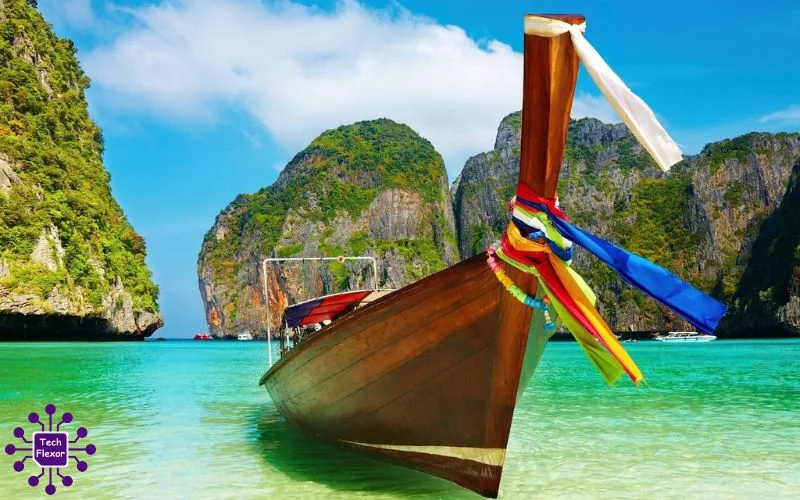 Traditional wooden boat floating on clear turquoise water near limestone cliffs under a bright blue sky